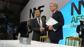 Messieurs Zhao (China Harbour Engineering) et Jim Dutton (Agence nationale des grands travaux) signant le contrat du Champ Triomphal.