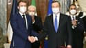 Au premier plan : Le président français Emmanuel Macron serre la main du Premier ministre italien Mario Draghi après la signature d'un traité bilatéral, le 26 novembre 2021 à Rome