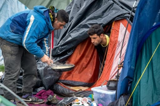 Des hommes se préparent à manger dans le camp de migrants de Grande-Synthe, près de Dunkerque, dans le nord de la France, le 20 octobre 2015 Des hommes se préparent à manger dans le camp de migrants de Grande-Synthe, près de Dunkerque, dans le nord de la France, le 20 octobre 2015