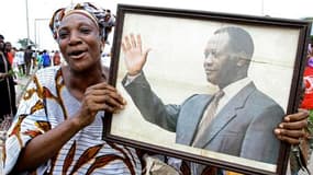 Une manifestante brandit un portrait d'Alassane Ouattara à Abobo, quartier d'Abidjan en proie aux violences post-électorales. Des milliers de femmes ont manifesté mardi dans plusieurs quartiers de la capitale économique de la Côte d'Ivoire pour réclamer l