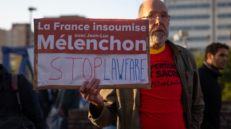 Un homme tient une pancarte "La France insoumise avec Jean-Luc Mélenchon - Stop Lawfare", le 19 septembre 2019 à Bobigny, à l'ouverture du procès.