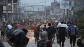 Des Palestiniens ramènent de l'aide humanitaire d'un point de distribution dans le camp de réfugiés palestiniens de Bureij, dans le centre de la bande de Gaza, le 9 juin 2025.