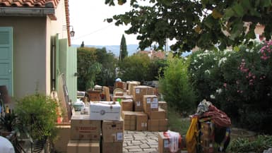 Des cartons de déménagement entreposés devant une maison verdoyante (Photo d'illustration).