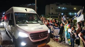 Des personnes acclament un véhicule transportant des otages libérés par le Hamas, dans le sud d'Israël, le 26 novembre 2023.