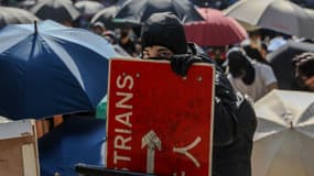 Des manifestants et des travailleurs font face à la police pendant une manifestation dans le centre de Hong Kong, le 13 novembre 2019