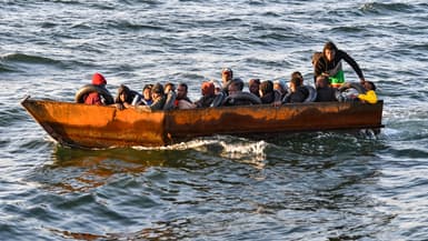 Des migrants originaires d'Afrique subsaharienne sont assis dans une embarcation de fortune en mer Méditerranée, au large de la ville de Sfax, au centre de la Tunisie, le 4 octobre 2022.