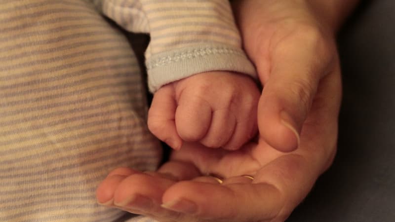 Une main de bébé et celle d'un adulte (Photo d'illustration)