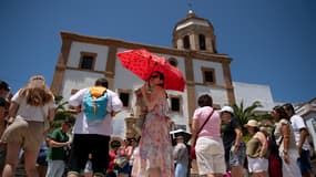 Une femme se protège du soleil avec un parapluie à Ronda, dans le sud de l'Espagne, alors que le pays fait face à la première vague de chaleur de la saison, le 28 mai 2025.