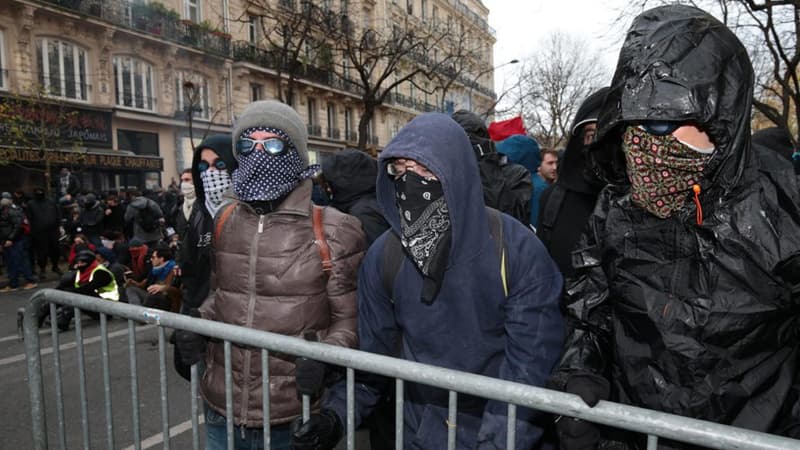 Des émeutiers masqués peu avant les affrontements avec la police, dimanche. 