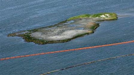 Barrages flottants pour protéger une petite île au large de la Louisiane de l'afflux de nappes de pétrole. Le gouvernement américain a intensifié ses efforts pour éviter une catastrophe écologique alors que l'énorme marée noire s'approche du delta du Miss