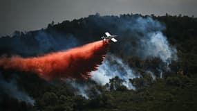 Un avion de lutte contre les incendies largue un produit retardant sur un incendie de forêt, près de Narbonne, le 8 juillet 2025 dans l'Aude