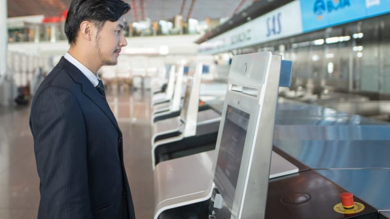 Un passager devant une borne biométrique pour faciliter son embarquement à l'aéroport de Francfort.