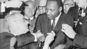 Le leader des droits civiques Martin Luther KIng (c) serre la main au président américain Lyndon Johnson à Washington, le 3 juillet 1964 