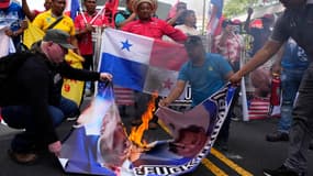 Des manifestants au Panama brûlent le portrait du président américain Donald Trump et de l'ambassadrice américaine Mari Carmen Aponte le 24 décembre 2024