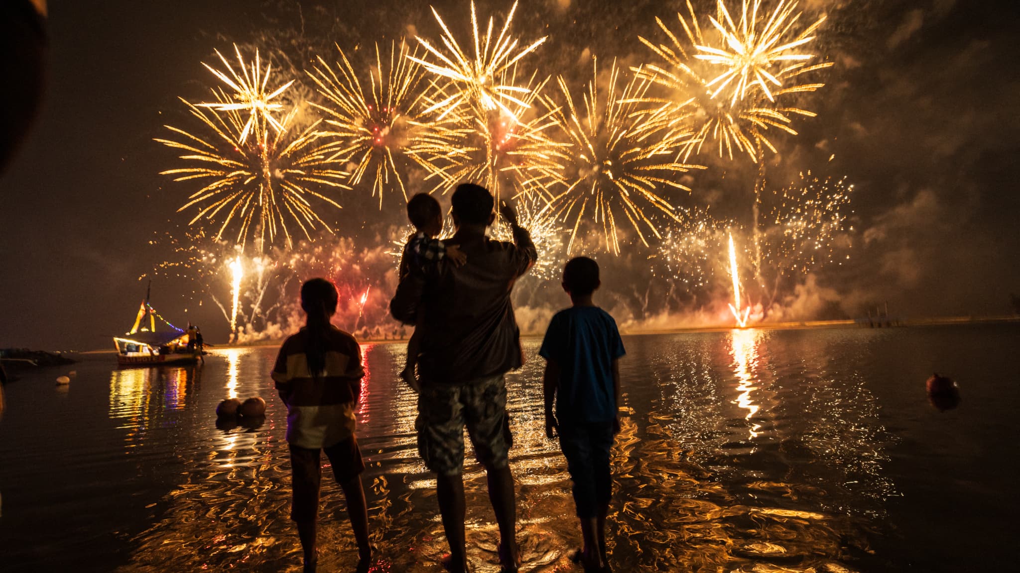 Des Indonésiens regardent des feux d'artifice alors qu'ils célèbrent le Nouvel An sur la plage d'Ancol à Jakarta le 1er janvier 2025.
