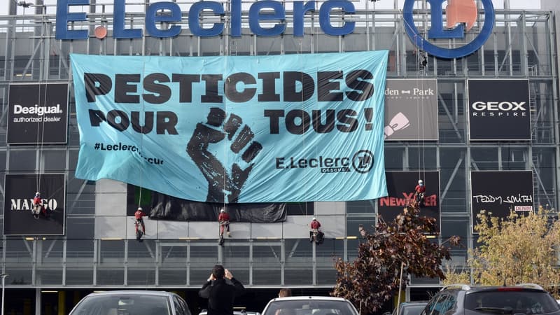 Des militants Greenpeace en train d'installer une banderole sur la façade d'un hyper marché Leclerc situé près de Toulouse. 