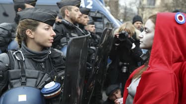 Une artiste déguisée en Marianne fait face aux forces de l'ordre, le 15 décembre 2018 sur les Champs-Elysées à Paris, en marge du rassemblement des gilets jaunes.