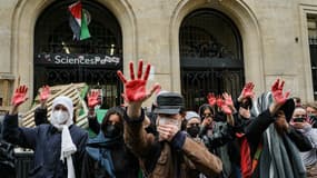 Les manifestants lèvent les mains enduites de peinture rouge pour symboliser le sang alors qu'ils participent à une manifestation devant l'Institut d'études politiques (Sciences Po Paris) occupé par des étudiants, en soutien aux Palestiniens, à Paris le 26 avril 2024.