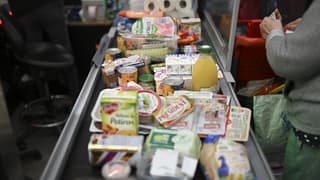 Des produits alimentaires et des achats sont placés sur le tapis roulant à la caisse du supermarché de Septemes-les-Vallons, près de Marseille, en novembre 2022.
