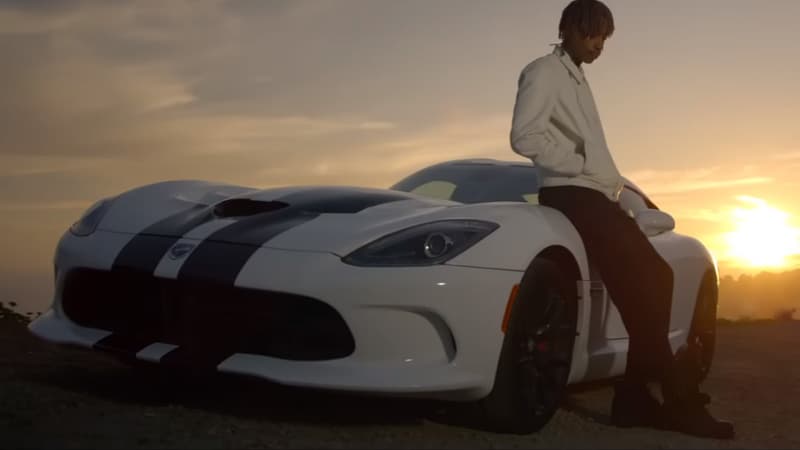 Wiz Khalifa rappe assis sur le capot d’une Dodge Viper SRT blanche à bandes noires de 2014 sur le titre See you again.