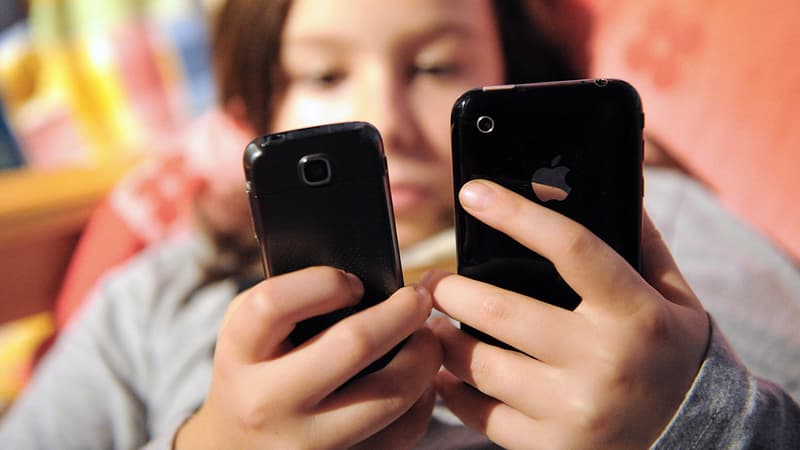 Une adolescente face à deux téléphones portables.
