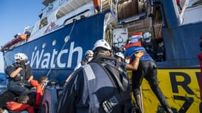 Des migrants du bateau Louise Michel, affrété par l'artiste de rue Banksy, montent à bord du bateau humanitaire Sea-Watch 4 lors d'une opération de secours, le 29 août 2020 au large des côtes maltaises