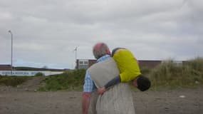 Un grand-père et son petit-fils en train de chahuter.