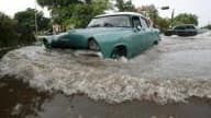 Après le passage de l’ouragan Gustav le 26 août 2008 sur Cuba, une vieille voiture tente de se frayer un chemin dans les rues inondées de la Havane.