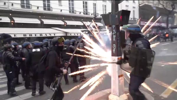 Un feu d'artifice éclate à proximité de membres des forces de l'ordre, vers Bonne Nouvelle, à Paris, lors de la manifestation du 23 mars.