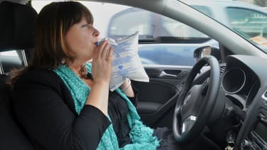 Une automobiliste souffle dans un éthylotest.