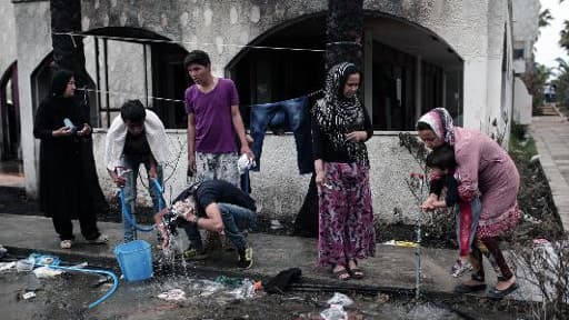 Des migrants afghans se lavent près d'un hôtel abandonné où ils ont trouvé refuge, le 27 mai 2015 sur l'île grecque de Kos