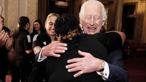 Le roi Charles III enlaçant des membres de l'équipe de rugby Black Ferns de Nouvelle-Zélande, au palais de Buckingham, le 11 septembre 2024.