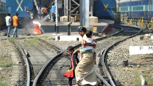 Des passagers traversent les voies ferrées de la ville indienne de Hyerabad, le 25 février 2015