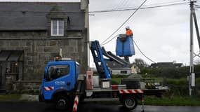 Un technicien d'Enedis raccorde des lignes électriques le 2 novembre 2023 à Lanildut, en Bretagne, après le passage de la tempête Ciaran 