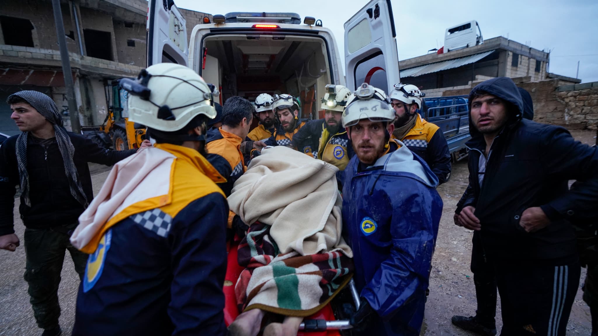Des membres de la défense civile syrienne, connus sous le nom de Casques blancs, transportent un blessé sorti des décombres dans une ambulance, suite à un tremblement de terre dans le village de Shalakh, dans la campagne orientale d'Idlib, tôt le 6 février 2023. Des membres de la défense civile syrienne, connus sous le nom de Casques blancs, transportent un blessé sorti des décombres dans une ambulance, suite à un tremblement de terre dans le village de Shalakh, dans la campagne orientale d'Idlib, tôt le 6 février 2023.