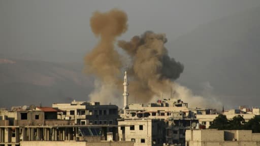 De la fumée s'élève après un bombardement du régime au-dessus de la ville sous contrôle rebelle de Saqba, dans la Ghouta orientale, près de Damas, le 11 mars 2018