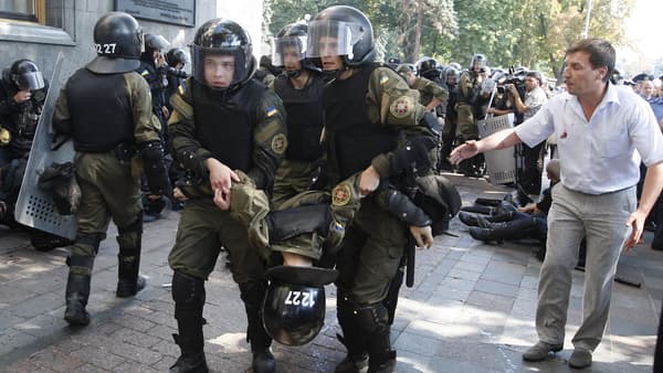 Des membres des forces de l'ordres portent l'un de leurs confrères blessés, le 31 août, à Kiev. 