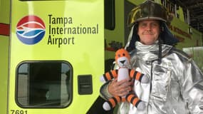Le tigre en peluche Hobbes dans les bras d'un pompier de l'aéroport de Tampa en Floride.