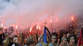 Des militants et des amis allument des fusées lors de la cérémonie funéraire du militaire ukrainien Roman Ratushny dans un cimetière de Kyiv le 18 juin 2022. Roman Ratuchny était une figure de proue du mouvement ukrainien pro-européen Maïdan, un militant anti-corruption et a combattu les forces russes avec l'armée ukrainienne. Il a trouvé la mort le 9 juin à l'âge de 24 ans près d'Izium, dans la région de Kharkiv, où les forces ukrainiennes affrontent l'armée russe. 