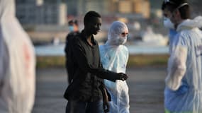Un migrant escorté après le sauvetage effectué par le Commandant Birot le patrouilleur de la marine française dans le port de Crotone en Italie le 3 mai 2015.