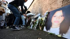 Une jeune femme dépose une fleur près du portrait de Dinah Gonthier, lors d'une marche blanche le 24 octobre 2021 à Mulhouse, dans le Haut-Rhin