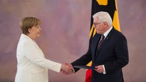 Le président allemand Frank-Walter Steinmeier serre la main de la chancelière Angela Merkel, le jour de sa réélection le 14 mars 2018 à Berlin. 