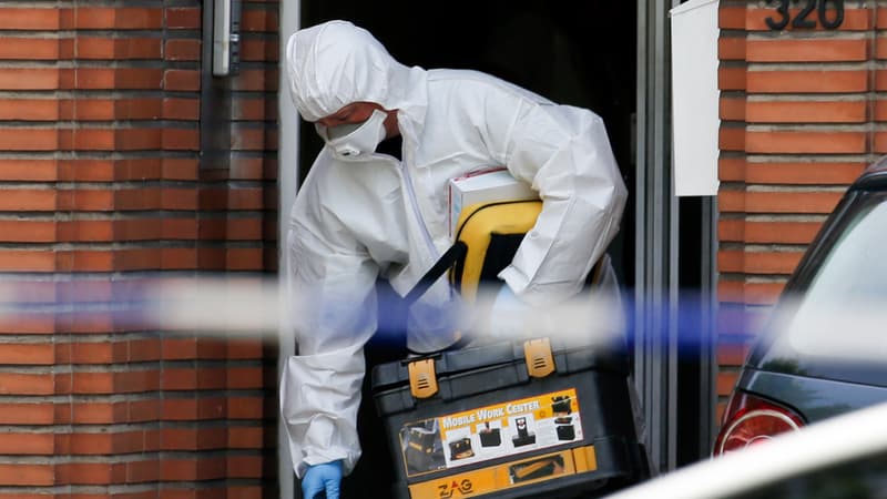Un enquêteur sort du domicile du suspect dans le quartier de Molenbeek.