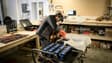 Un mécanicien travaille sur un module de batteries pour voiture électrique dans l'atelier de réparation spécialisé Revolte, à Carquefou (Loire-Atlantique), le 30 novembre 2022