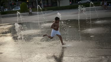 Un enfant se rafraîchit dans une fontaine de Cordoue, en Espagne, le 7 juillet 2017