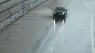 Une voiture circulant sur une route inondée lors d'un épisode de pluie intense dans le bassin lyonnais (Rhône), dimanche 28 avril 2024.