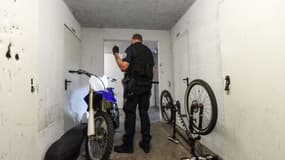 Un policier inspecte une moto dans la cave d'un immeuble dans le cadre d'une opération anti-rodéos urbains, le 11 août 2022 à Nantes