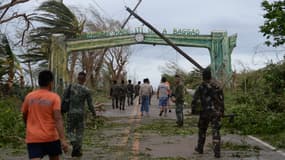 Les secours nettoient une route après le passage du typhon Mangkhut, au nord de Manille le 15 septembre 2018. 