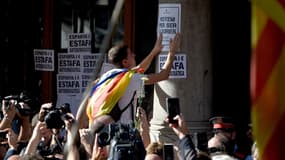 Un manifestant pro-indépendance colle des affiches pendant une démonstration de force des partisans du "oui", le 20 septembre, à Barcelone.
