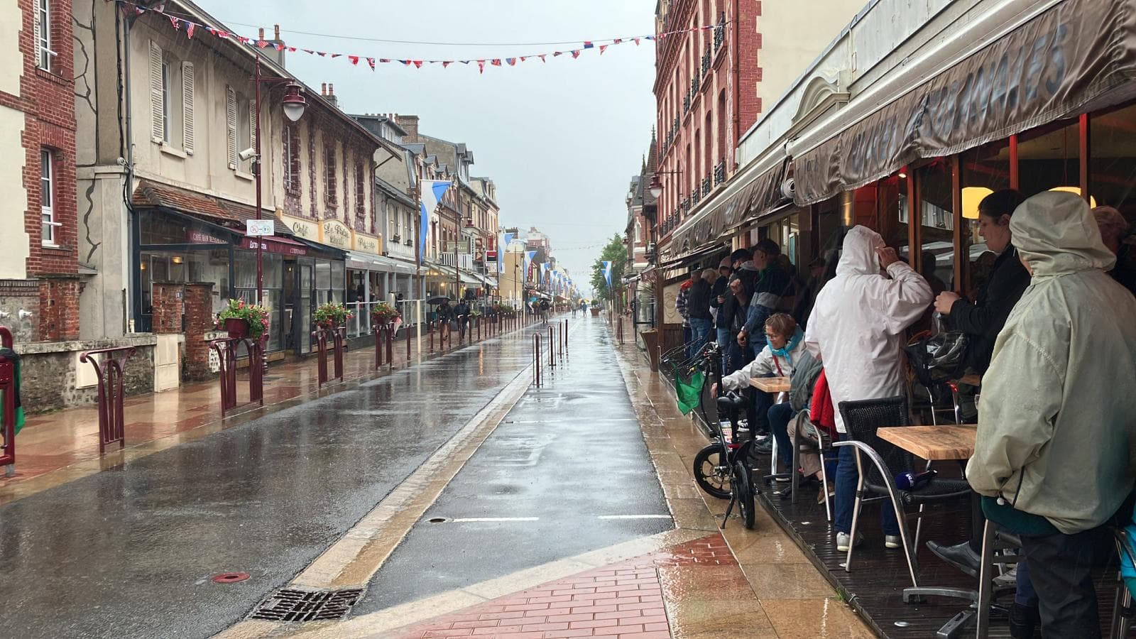 À Houlgate, le public contraint de s'abriter de la pluie en attendant la flamme ce jeudi 30 mai. 